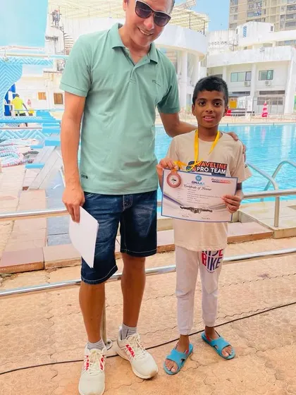 A coach's support is vital on race day. Here, one of our coaches congratulates Bryce on his performance at the GMAAA swim meet. We ensure our swimmers have guidance and encouragement right by the poolside during competitions.