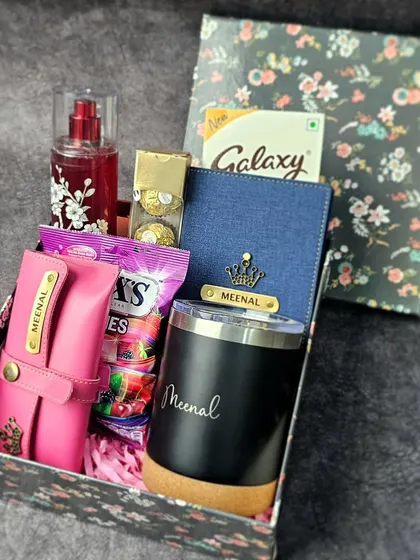 A cute travel hamper for the strong woman in your life. It includes a personalized passport holder, a custom tumbler, perfume, and snacks, all in a floral box.