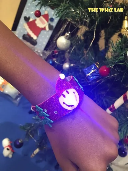 Jingle all the way with science! A student wears a DIY light-up Christmas band they created, learning about simple circuits while getting into the festive spirit.