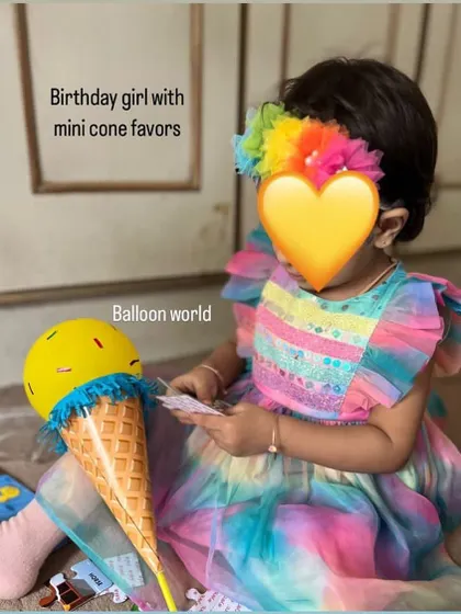 We love getting photos from clients. Here's the adorable birthday girl with one of our mini ice cream cone favors. It perfectly matches her colorful dress.