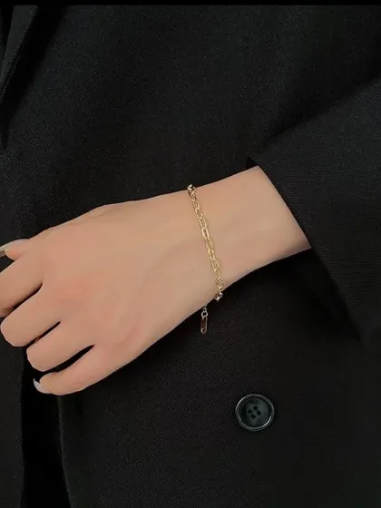 A simple and chic paperclip chain bracelet worn on the wrist. This versatile piece is a must-have for any modern jewelry collection.