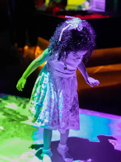 A candid moment of a child dancing on the colorful, interactive floor.