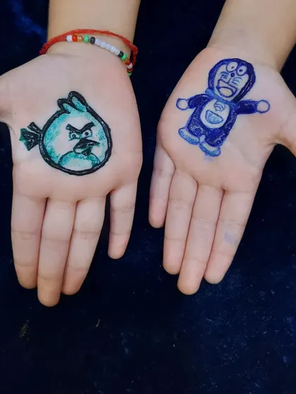 Mehndi is for kids too. I love getting cute requests like this Angry Bird and Doraemon, created with skin-safe blue and green colored henna.