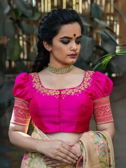 A repeat of the festive pink blouse with gold embroidery, paired with a classic gold choker.