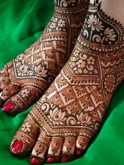 Bridal beauty extends to the feet with this exquisite lotus-themed design. The intricate patterns cover the feet completely, featuring delicate check-work, floral details, and a beautiful symmetry that complements the bride's overall look.