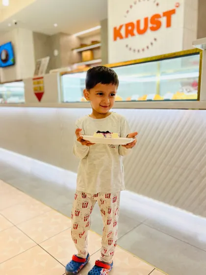 A happy little customer holding up his plate with our cheesecake. It's moments like these that make all the hard work in the kitchen worthwhile.
