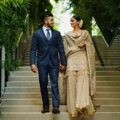 This couple's coordinated look is perfect for a daytime wedding or engagement. I can create a similar sequined sharara set and a classic suit for a polished look.