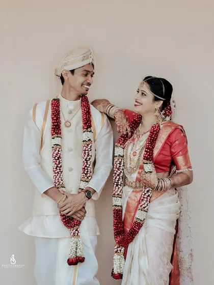 A stylish and happy wedding portrait, with the bride leaning on the groom's shoulder, both sharing a smile.