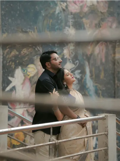 Using the city's textures and art as a backdrop. This shot was taken on a public walkway, using the railings to frame the couple and create a sense of intimacy amidst the urban environment.
