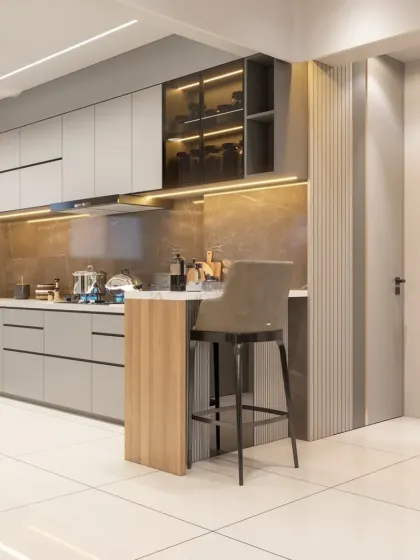 An open-plan kitchen with a small breakfast bar extension. The grey cabinets and marble-effect backsplash are complemented by wood-paneled accents, adding warmth and texture to the modern design.