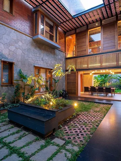 This multi-level courtyard design shows a blend of materials and textures. We used stone walls, wooden screens, and a mix of pavers and grass, with a raised planter box as a central feature.