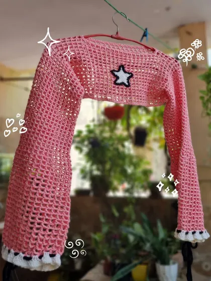 A closer look at our pink mesh bolero crop top. The star patch and ruffled details on the cuffs make this a fun and trendy piece to layer over your favorite top or dress.