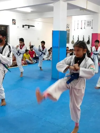 A student practices a front kick during her form.