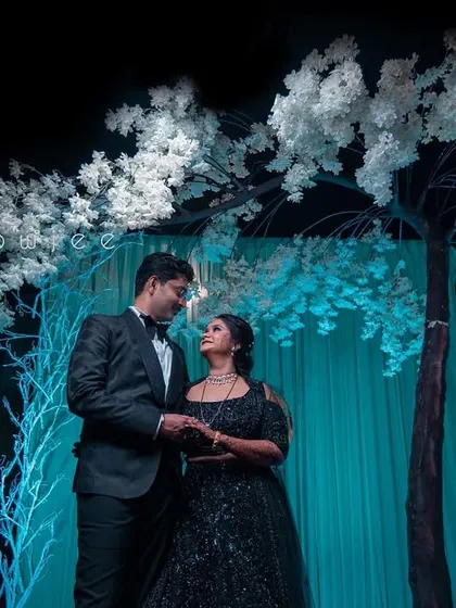 A romantic portrait of the couple under a stunning artificial white tree, part of their reception decor.