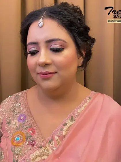 A close-up of the finished makeup. The soft pink tones on the eyes and lips create a fresh and youthful look that enhances her natural beauty.