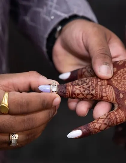 A close-up of the ring ceremony, where you can see the deep color of the henna on her finger.