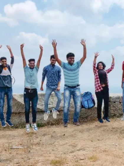 A team celebrates reaching the top with a coordinated jump, a perfect picture of unity and shared joy.