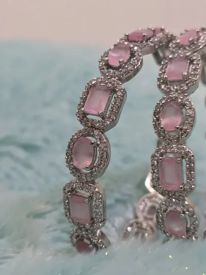 A pair of modern AD bangles with pastel pink stones.