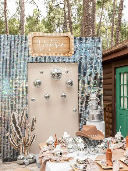 A glittering cowboy or cowgirl theme that's perfect for an adult birthday or even a unique baby shower. The sequin backdrop, disco balls, and cactus prop create a fun "disco rodeo" vibe.