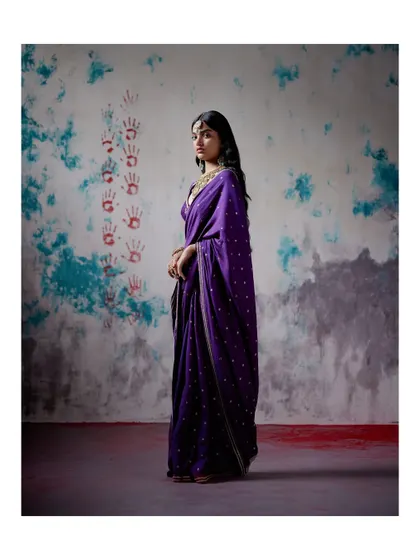 This classic purple saree with delicate buti work is a perfect example of understated elegance. It’s a timeless piece that can be dressed up or down for any festive occasion.