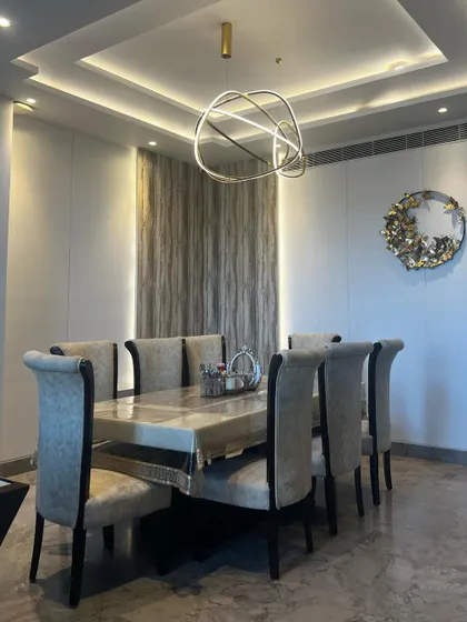 Another perspective of the dining space, highlighting the beautiful ceiling design with cove lighting that frames the area.