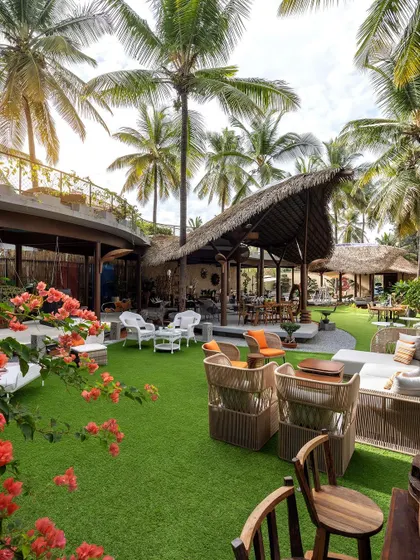 The allure of outdoor living is in every detail. This project combines lush lawns, tropical plants, and comfortable furniture under a traditional thatched roof, celebrating natural materials and local craftsmanship.