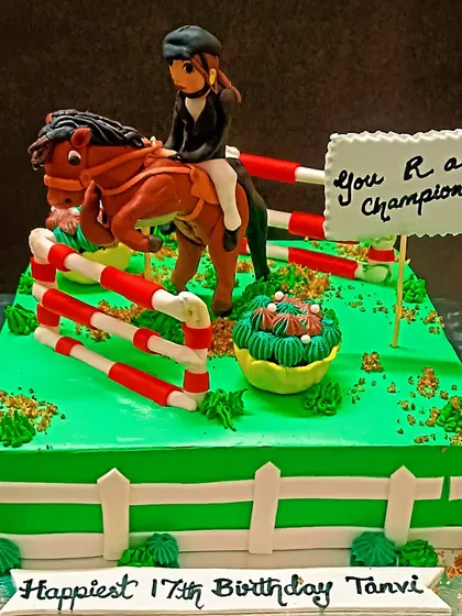 A detailed horse riding-themed cake for a 17th birthday, showing a rider jumping over an obstacle.