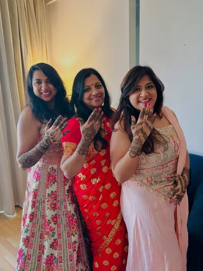 The bride with her family, all showing their henna-adorned hands. Mehndi is a celebration for everyone.