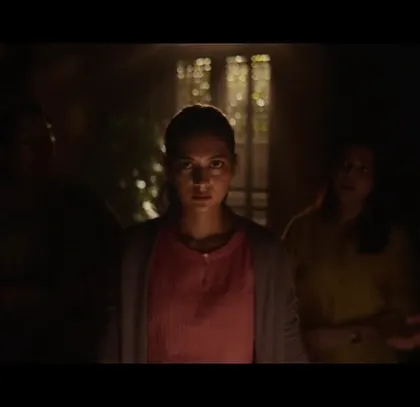 A powerful shot from the Air India ad, capturing a moment of suspense and hope. The dark, atmospheric lighting highlights the characters' expressions and simple, authentic wardrobe.