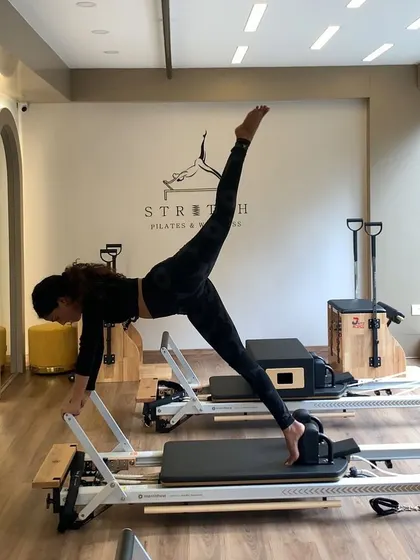 The classic stretch Pilates pose on the reformer. This move challenges your balance, flexibility, and core control all at once.