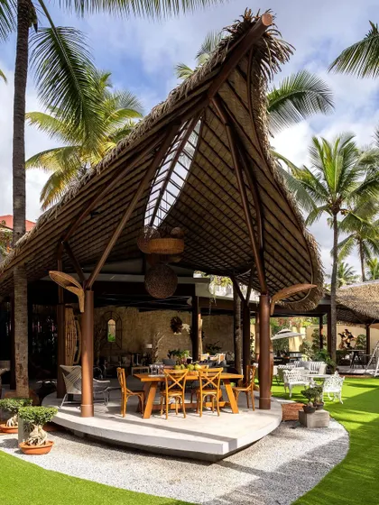 A close-up of a dining gazebo with a beautifully crafted thatched roof. The structure is supported by heavy wooden posts, showcasing our commitment to using natural, sturdy materials in our outdoor designs.