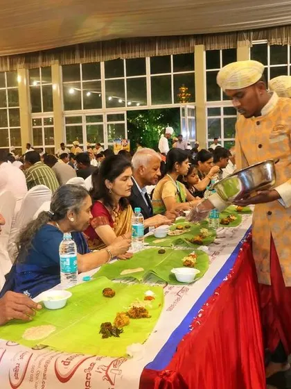 Personal attention is key in my service. Here, one of my senior staff members in traditional attire serves an elderly guest, showing the respect and care we bring to every table.