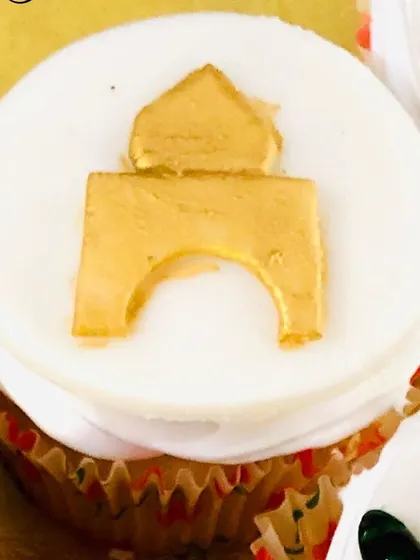 A custom cupcake topper for Bakrid, featuring a golden arch design to represent a mosque.