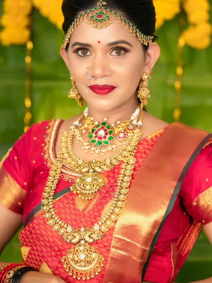 A close-up of the model's face, showing the intricate details of the choker, haram, and matha patti.