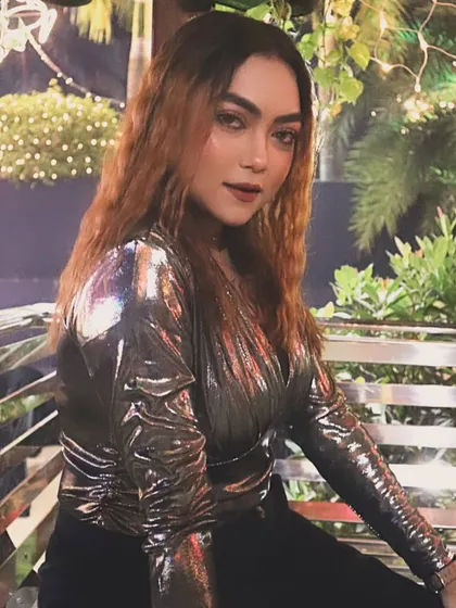 Posing outdoors at night, with beautiful bokeh lights in the background.