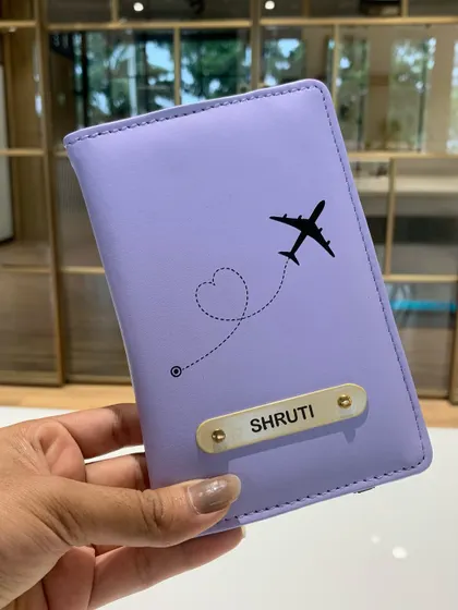 A personalized lavender passport cover with the name 'Shruti' and a cute airplane charm. A perfect Rakhi gift for a sister who loves to travel.