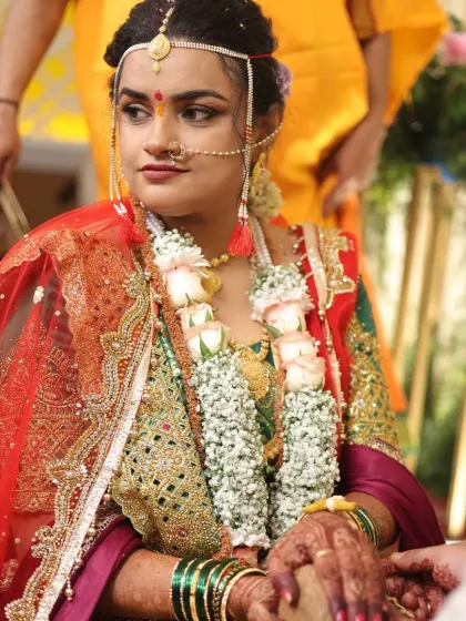 The bride adorned with a floral garland during her ceremony. Her makeup holds up perfectly, maintaining its elegance and definition.