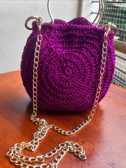 This deep purple Rose Bag features a long golden chain, perfect for wearing as a crossbody or over the shoulder.