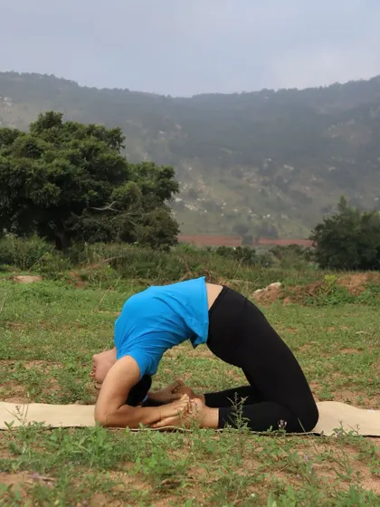 A deep variation of Camel Pose, Kapotasana, practiced outdoors.