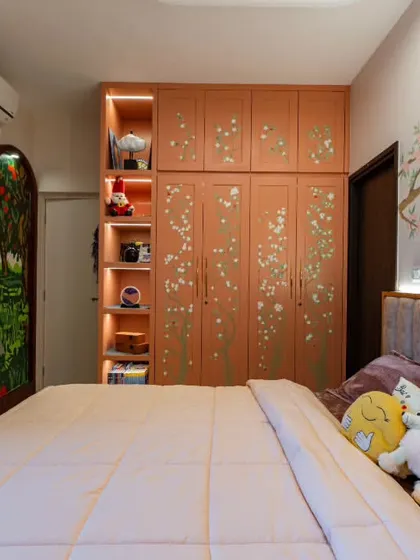 In this whimsical bedroom, I combined two murals: an apple orchard on the arched panels and cherry blossoms on the wardrobe. This space was designed to grow with a child, blending storytelling with a style that sparks imagination.