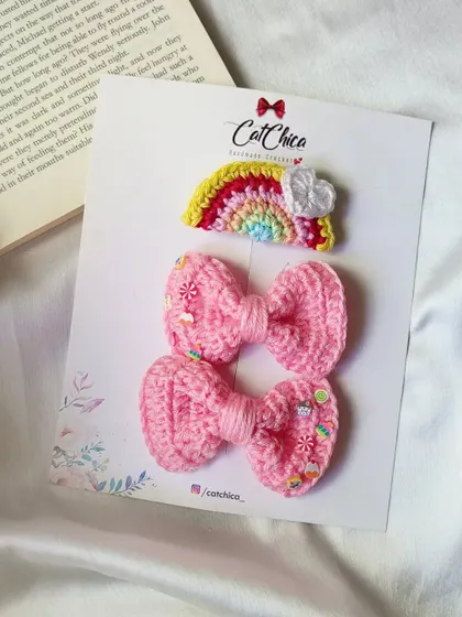A sweet set of pink crochet bows with candy sprinkle details, paired with a rainbow clip.