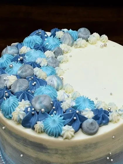 A detailed view of the piped buttercream swirls. The mix of different piping tips and colors creates a beautiful, textured look, finished with silver sugar pearls.