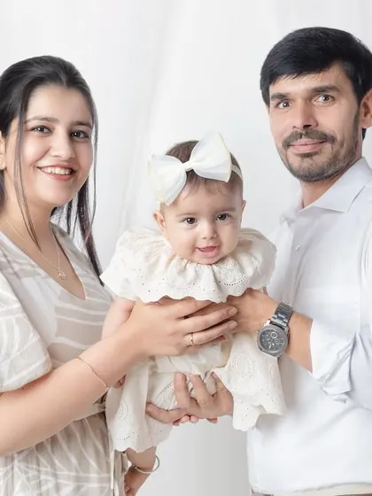 A happy family of three. The baby's smile is just precious in this classic studio portrait.