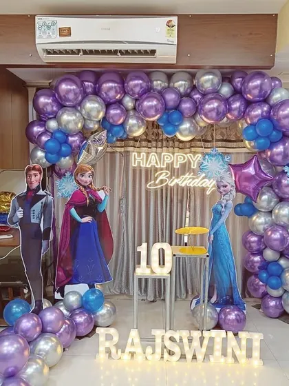 I bring popular themes to life for children's birthday parties. This Frozen-themed celebration includes a full balloon arch, character cutouts, and custom light-up lettering for the birthday girl's name.