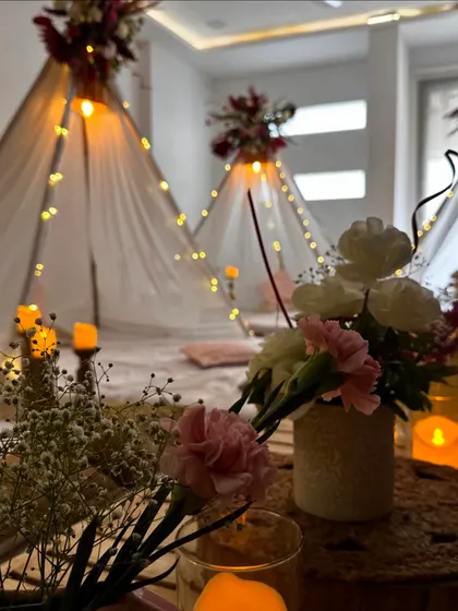 A close-up of the slumber party decor, highlighting the fresh flowers and candles that add a touch of elegance to the cozy setup.
