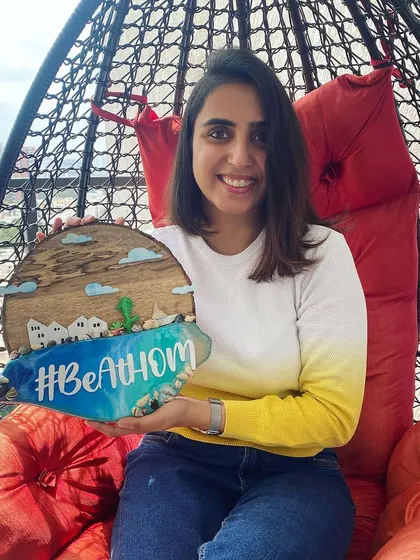 Here I am, holding a finished resin beach nameplate made for a homestay in Goa. The resin creates a stunning, glossy wave effect, complete with real shells, bringing the coastal vibe to life.