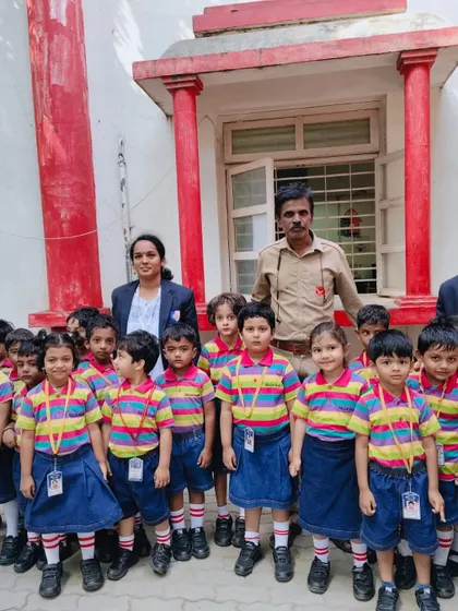 Our students pose with a postman, getting to meet one of the community helpers they learn about in class.