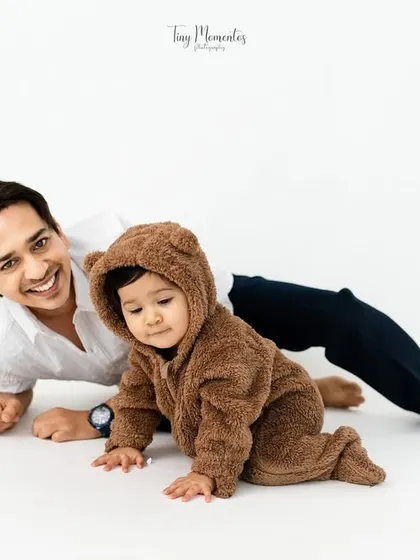 A playful moment on the floor with dad and his little bear. This image showcases a fun, interactive pose that brings out genuine smiles from both father and son.