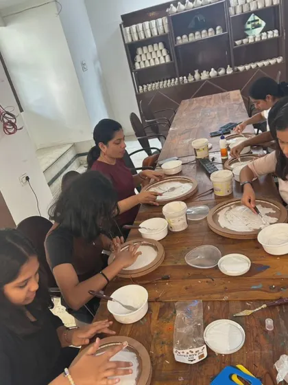 A table of students working diligently during a moon lamp workshop, each focused on their own celestial creation.