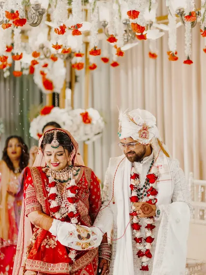 The bride and groom walk together during their Pheras, their hands tied in a sacred bond. This shot captures the solemnity and commitment of the traditional Hindu wedding ritual.